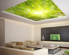 a living room with a ceiling that has a green tree print on the ceiling and white couches