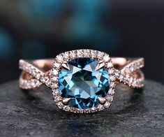 a blue diamond ring on top of a rock