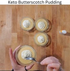 a person holding a spoon in front of some puddings on a wooden table with the words keto butterscotch pudding