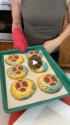 a woman is holding a tray with cookies on it