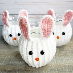 three knitted easter bunnies in white and pink with bunny ears on each one