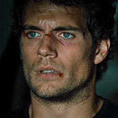 a man with blue eyes and blood on his face