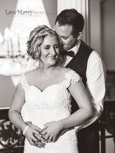 a bride and groom standing together in front of a chandelier