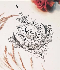 a drawing of the moon and flowers on a piece of paper next to some dry grass