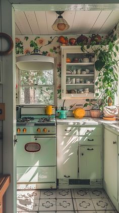 an old fashioned kitchen with green cabinets and floral wallpaper on the walls, along with white tile flooring