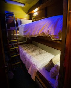 bunk beds are lit up with purple lights in the room that is used as a bedroom