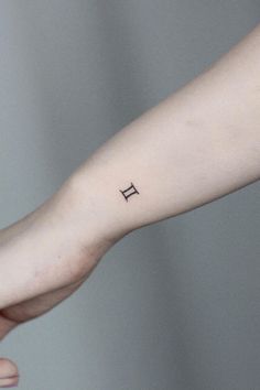 a person's arm with a small tattoo on the left side of their wrist