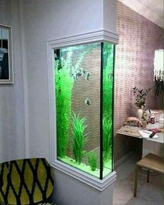 a fish tank in the corner of a room with plants and other things inside it