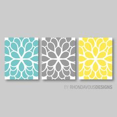 three yellow and blue wall art prints with flowers on the bottom, one in grey