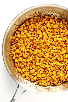 a pot filled with corn on top of a white table