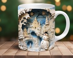 a white coffee mug with a snowman and castle on it sitting on a wooden table