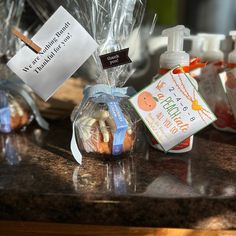 several bottles of hand sanitizers and soaps on a counter with labels in plastic bags