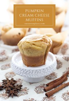 pumpkin cream cheese muffins on a plate with cinnamon sticks