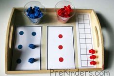 a tray with two cups and some red white and blue candies in them on it