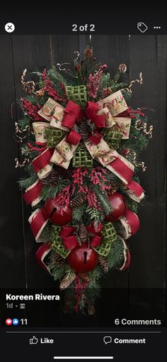 a christmas wreath hanging on the side of a wooden fence with red and green decorations