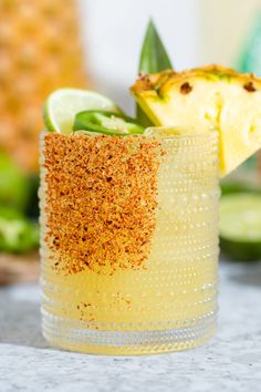 a pineapple and lime drink with spices on the rim