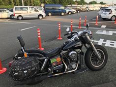 a motorcycle parked on the side of a road next to traffic cones and orange poles