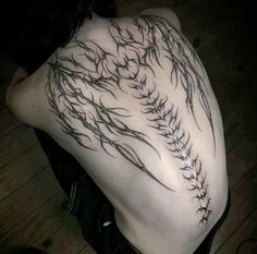 the back of a person's body with tattoos on it