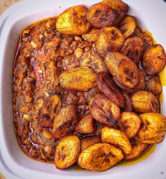 a white bowl filled with cooked bananas on top of a table