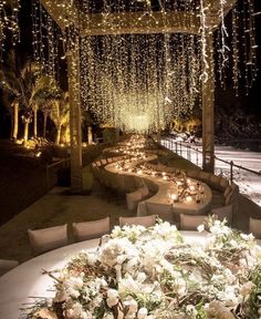 an outdoor seating area decorated with lights and flowers