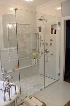 a bathroom with a walk in shower next to a bath tub