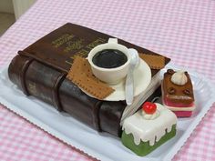 a cake made to look like an old book with coffee and cookies on the table