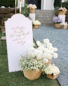 white flowers are in baskets next to a sign that says thank you for the bride and groom