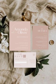 the wedding stationery is laid out on top of a blanket with flowers and greenery