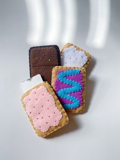 three small pieces of bread with icing and sprinkles on them sitting next to each other