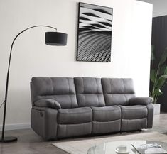 a living room scene with focus on the reclining sofa and floor lamp in the corner