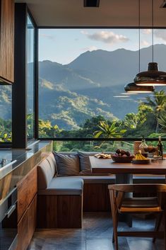 a table with two chairs and a bench in front of a window overlooking the mountains