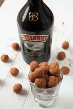 a bottle of bailey's is next to a glass filled with chocolate balls