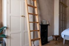 a ladder leaning up against the wall next to a bed