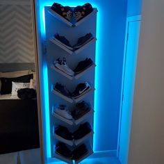 there is a shoe rack in the corner with shoes on it and blue light coming from behind