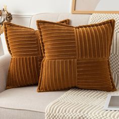 two brown pillows sitting on top of a couch