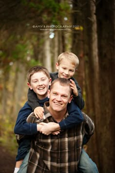 a man holding two boys on his shoulders in front of some trees and leaves with the caption, happy photography 2013