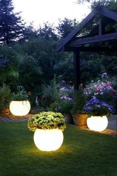 three large planters with flowers in them on the grass