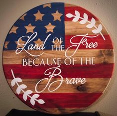 a wooden sign with the words land of the free because of the brave on it