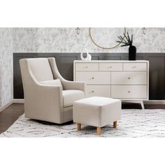 a white chair and footstool sitting on top of a rug next to a dresser