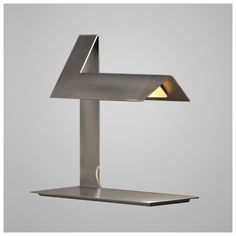 a lamp that is sitting on top of a metal stand with a light in the middle