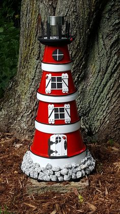 a red and white traffic cone sitting next to a tree