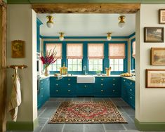 a kitchen with blue cabinets and an area rug on the floor in front of it