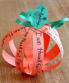 an origami pumpkin made out of strips of paper with words written on it