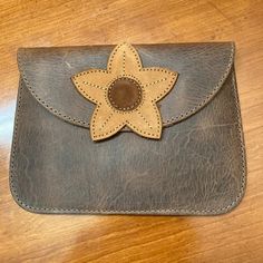 a wallet with a flower on it sitting on a table