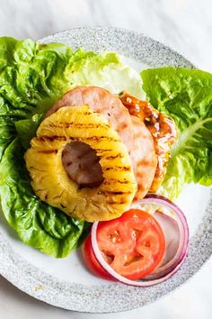 a white plate topped with lettuce and meat