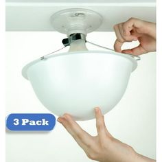 two hands are pulling the light bulb off of a ceiling fixture that is being held by someone's hand