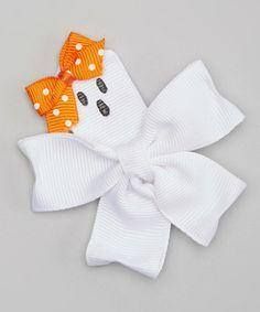 a white bow with orange polka dots and a ghost face on the front is shown