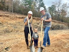 two adults and a child with shovels on a dirt road