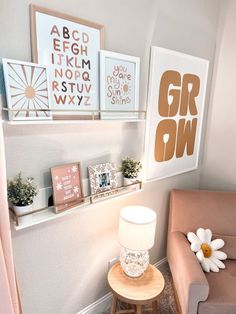 a living room filled with furniture and framed pictures on the wall above a lamp next to a chair