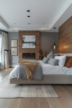 a large bed sitting on top of a wooden floor next to a fireplace in a bedroom